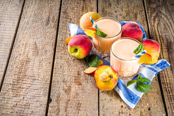 Summer breakfast drink, fresh blended peach smoothie, peach yogurt with nectarine fruit slices,...