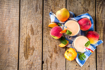 Summer breakfast drink, fresh blended peach smoothie, peach yogurt with nectarine fruit slices,...