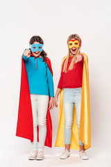 Girls playing superheroes isolated in white background