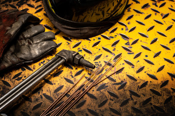 Gas welding and safety equipment on a grunge yellow checkerplate background surface