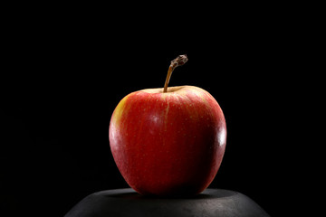 Close up of red organic fresh apple on black background. Healthy food concept.