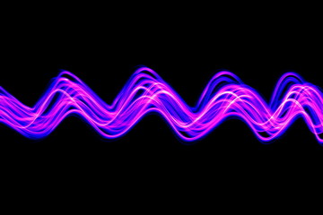 Long exposure photograph of neon pink and purple colour in an abstract swirl, parallel lines pattern against a black background. Light painting photography.