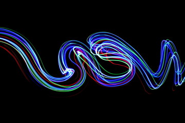 Long exposure photograph of neon multi colour in an abstract swirl, parallel lines pattern against a black background. Light painting photography.