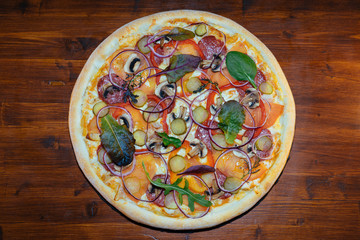 Italian pizza with mushrooms and herbs on a wooden table