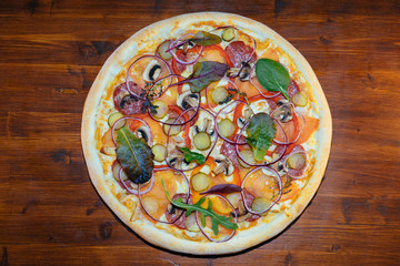 Italian pizza with mushrooms and herbs on a wooden table