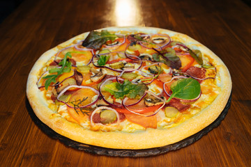 Italian pizza with mushrooms and herbs on a wooden table