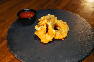 fish or meat in breaded batter with sauce on a tray of slates