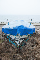 Fototapeta na wymiar boat wrapped in protective plastic on beach 