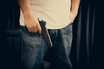 Men wearing t-shirts, jeans Standing holding a gun in the house