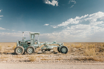 Parked road grader used for rehabilitating the gravel road s in the Etosha National Park of Namibia