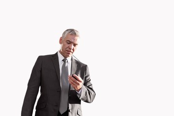 Cutout of Mature businessman standing while using smartphone in airport
