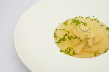 Soup with egg and meat, on a large white plate, white background