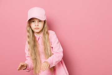 Little girl in pink clothes and a medical mask on a pink background