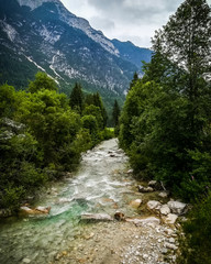 Fototapeta na wymiar Idyllic evening in Leutasch, Tirol mountain valley during summer evening on a bridge across fast rocky river