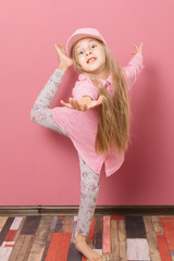 Little girl in pink clothes and a medical mask on a pink background