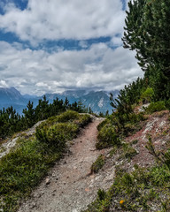 Fototapeta na wymiar Dramatic vintage view of narrow and difficult rocky trekking trail across mountain peak at Seefeld, Tirol region