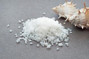 Fototapeta na wymiar Large sea salt and sea shells on the table