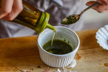 Adding olive oil to condiment sauce - preparing food