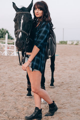 Fototapeta premium beautiful stylish fashion woman near horse on ranch. Fashion girl hugging a horse.