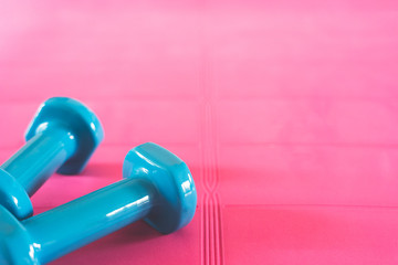 A couple of blue dumbbell laying on a yoga mat.
Indoor workout during quarantine theme