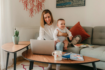 young business mother works from home with her cute baby