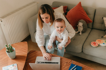 young business mother works from home with her cute baby