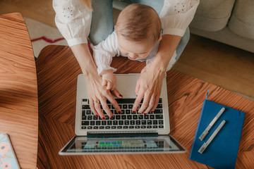 young business mother works from home with her cute baby
