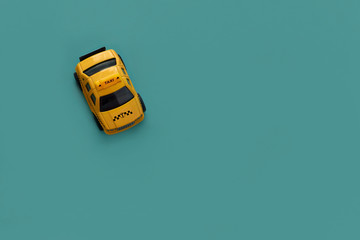 yellow taxi machine on green background with copy space, top view, flat lay