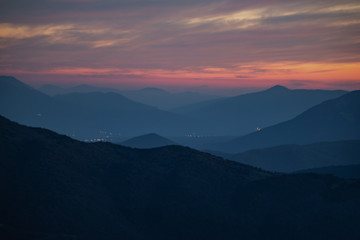 Sunset mountain peaks sky panorama. Mountain peaks sunset view. Sunset mountain peaks silhouette. Mountain sunset sky clouds
