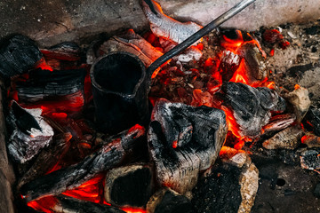 black hot coals in the forge during the melting of tin in a special tank
