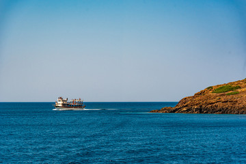 The ship is sailing along the coast