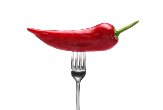 side view of red pepper on fork on white background. Domestic cultivation. Fresh vegetables. Vegetarian dinner. Paprika on a fork. Isolated from background © Andriy Medvediuk