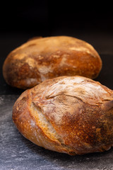 Dark mood and tone Home Cooking Homemade Organic rustic Sourdough bread on black background with copy space