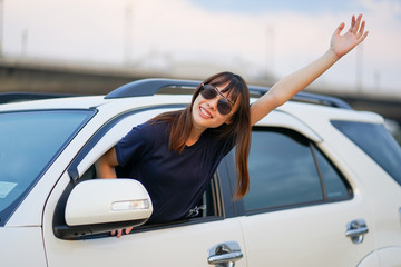 ํYoung Asian woman wearing sun glasses out of white SUV car window at the riverside, Travel car in vacation