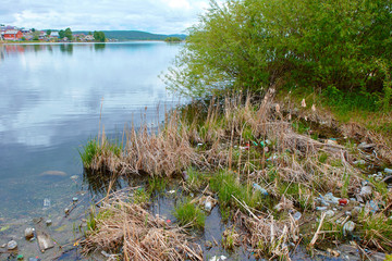 The problem of pollution and ecology of reservoirs. Garbage on the shoreline in the city limits
