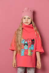 Little girl in pink clothes on a pink background