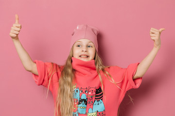 Little girl in pink clothes on a pink background