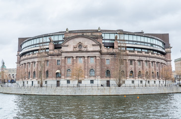 Fototapeta premium Riksdag (Parliament) Building at the bank of canal gainst cloudy sky in Stockholm, Sweden.