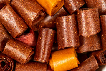 Closeup top view macro photography of tasty healthy homemade organic dessert made of different kinds of fruits. Rolls of dried fruit leather perfect for eating as healthy snack. 