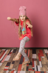 Little girl in pink clothes on a pink background