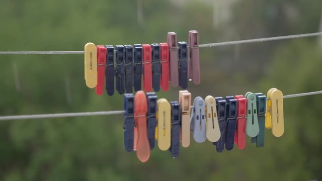 It is raining outside. Clothes are pinned on a bandage, swaying in the wind.