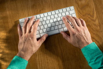 men's hands type on the keyboard
