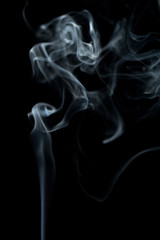 white smoke dances in different shapes on a black background