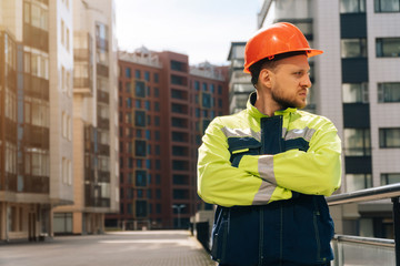 Closeup of a builder engineer holding a helmet with his hand. A man wants to take off his special helmet.