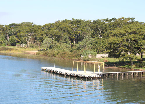Lago com vegeta&ccedil;&atilde;o na margem e porto (embarcador)