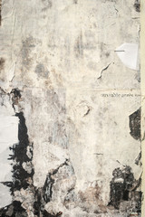 old cracked bulletin board wall with rests of paper, white grunge background