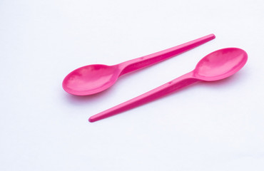 two vibrant pink plastic  spoon isolated on white