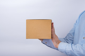 Man holding square cardboard box on white background. copy space. moke up