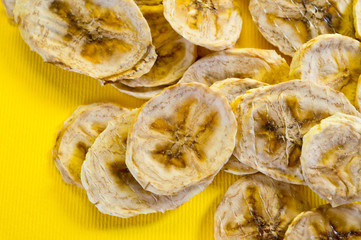 Dried banana chips, sliced in thin circles. Background for healthy and natural nutrition.
