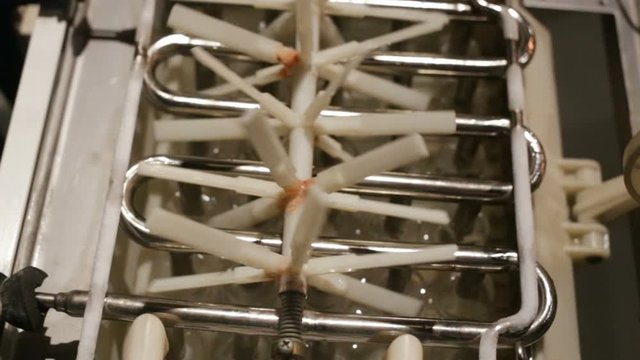 automatic ice-making plant close-up. The zigzag frost heat exchanger is heated, ready finger ice falls into the water in the hopper